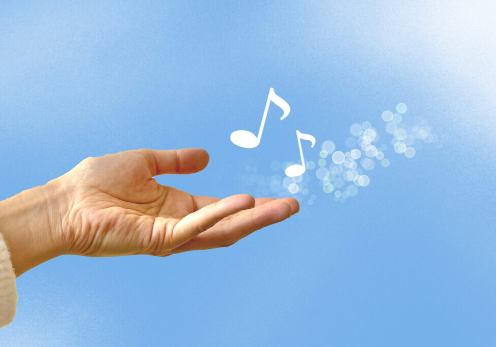 musical notes and blue sky A hand outstretched over blue sky, with white music notes floating from the hand. Represents the gift of music for grief support