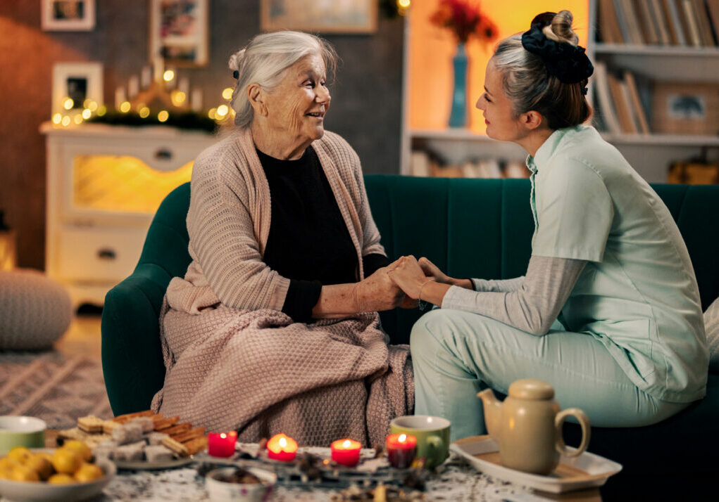 elderly lady and caregiver sharing an emotional moment togethet during christmas day