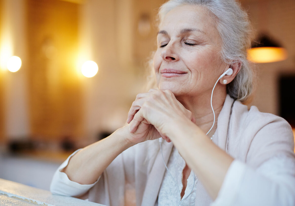 Mature woman with earphones listening to music