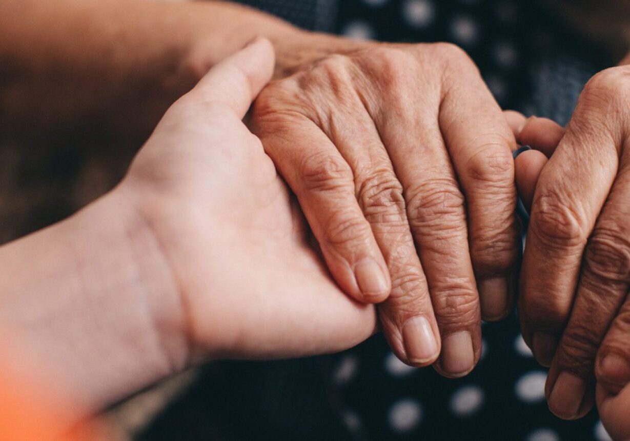 Grandmother and granddaughter holding hands - you only see a close of up their hands