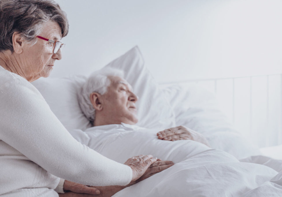 Elderly woman supporting sick husband