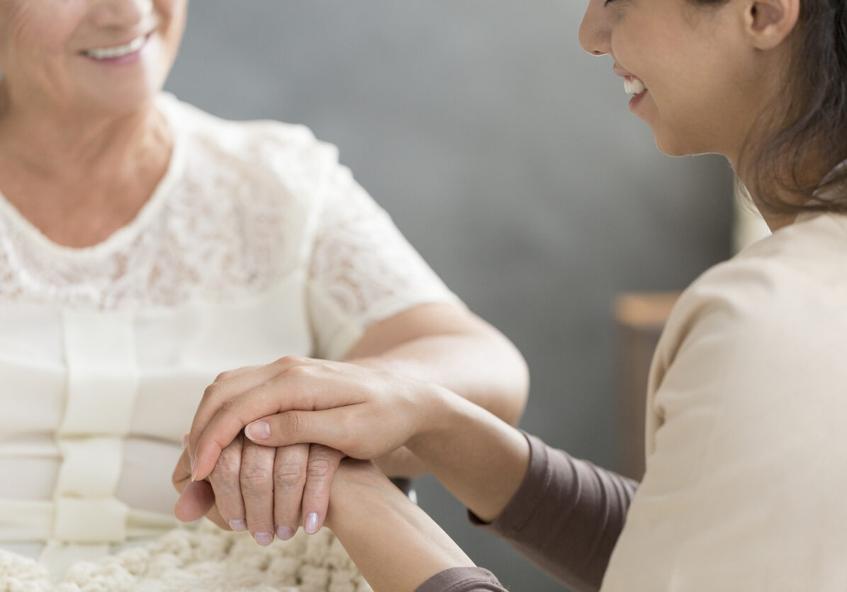 Close-up of volunteer's hand taking care of senior person
