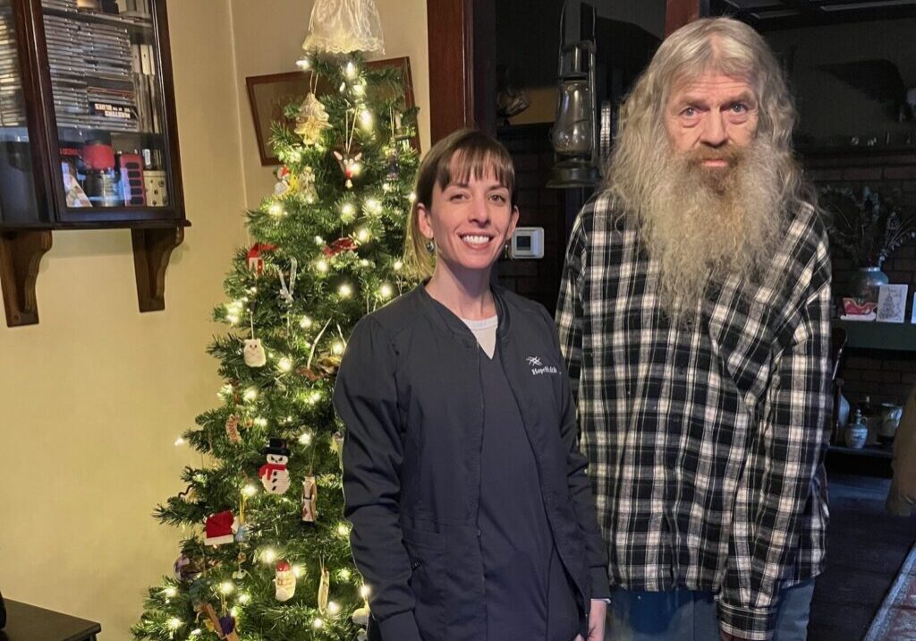 Man standing with nurse in front of Christmas tree