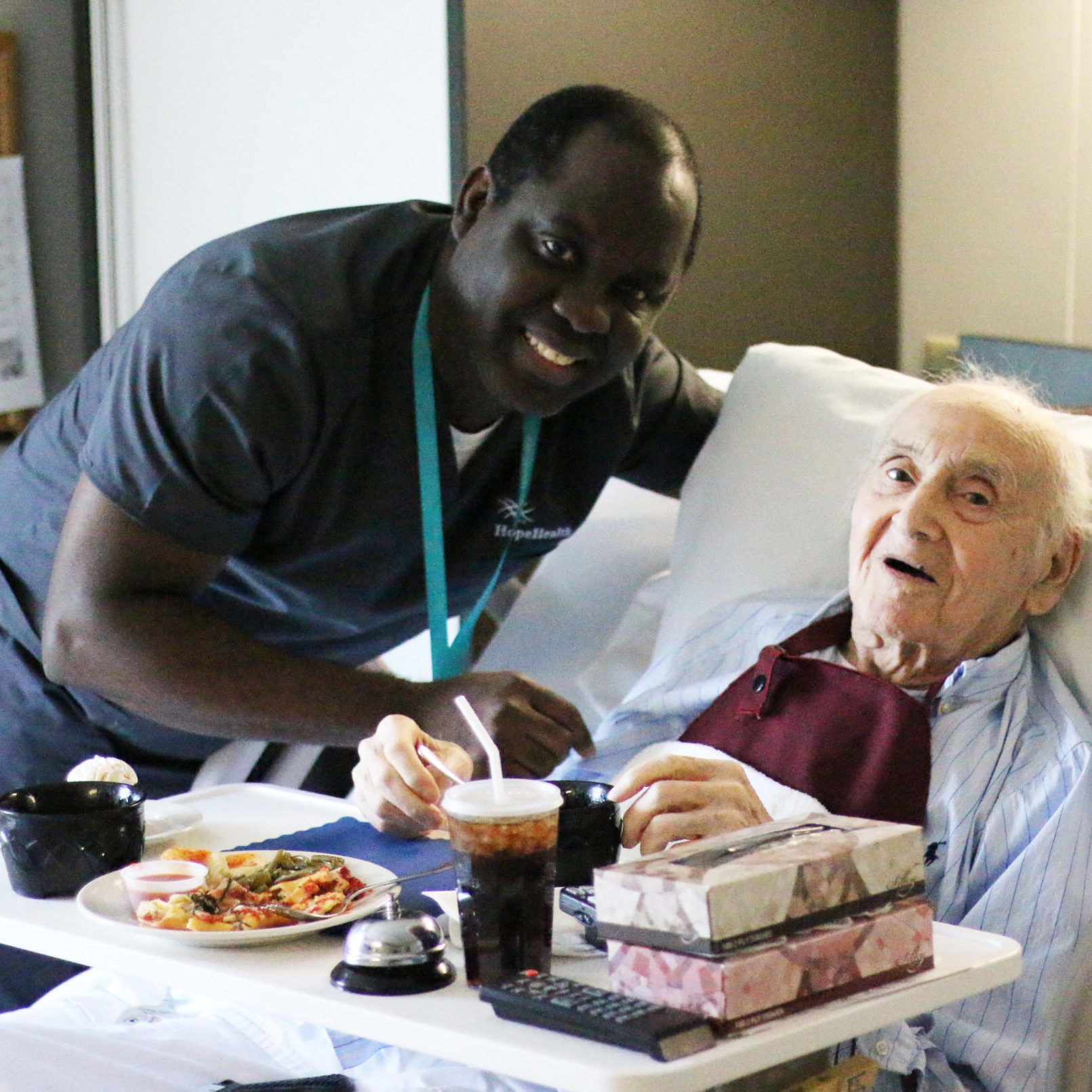 Patrick Wallace, hospice aide, and patient Young man standing with geriatric patient